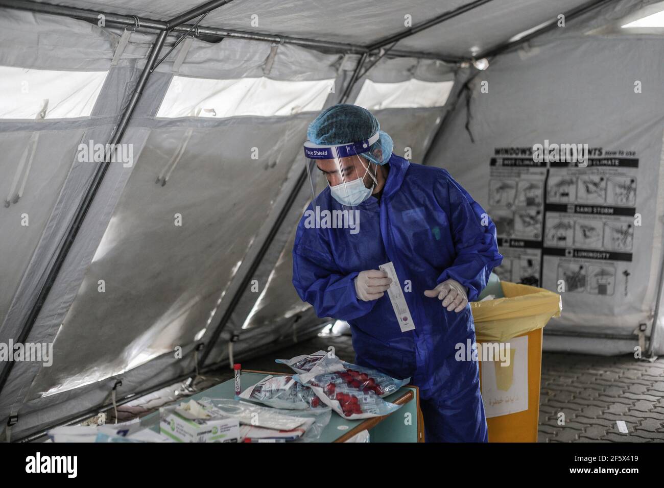 Gaza, Palestina. 28 Marzo 2021. Un medico si prepara a prelevare campioni di tampone da sottoporre a test per la malattia del coronavirus (Covid-19). Il Ministero degli interni di Gaza ha annunciato nuove misure il 24 marzo 2021, con l'aumento del numero di casi COVID-19. Credit: SOPA Images Limited/Alamy Live News Foto Stock