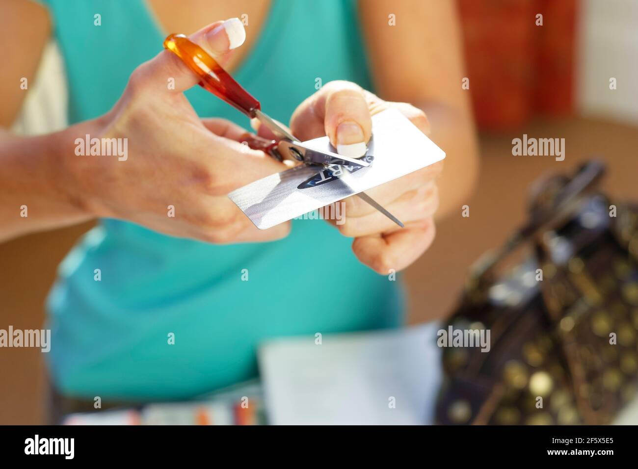 La donna il taglio di carta di credito a metà Foto Stock