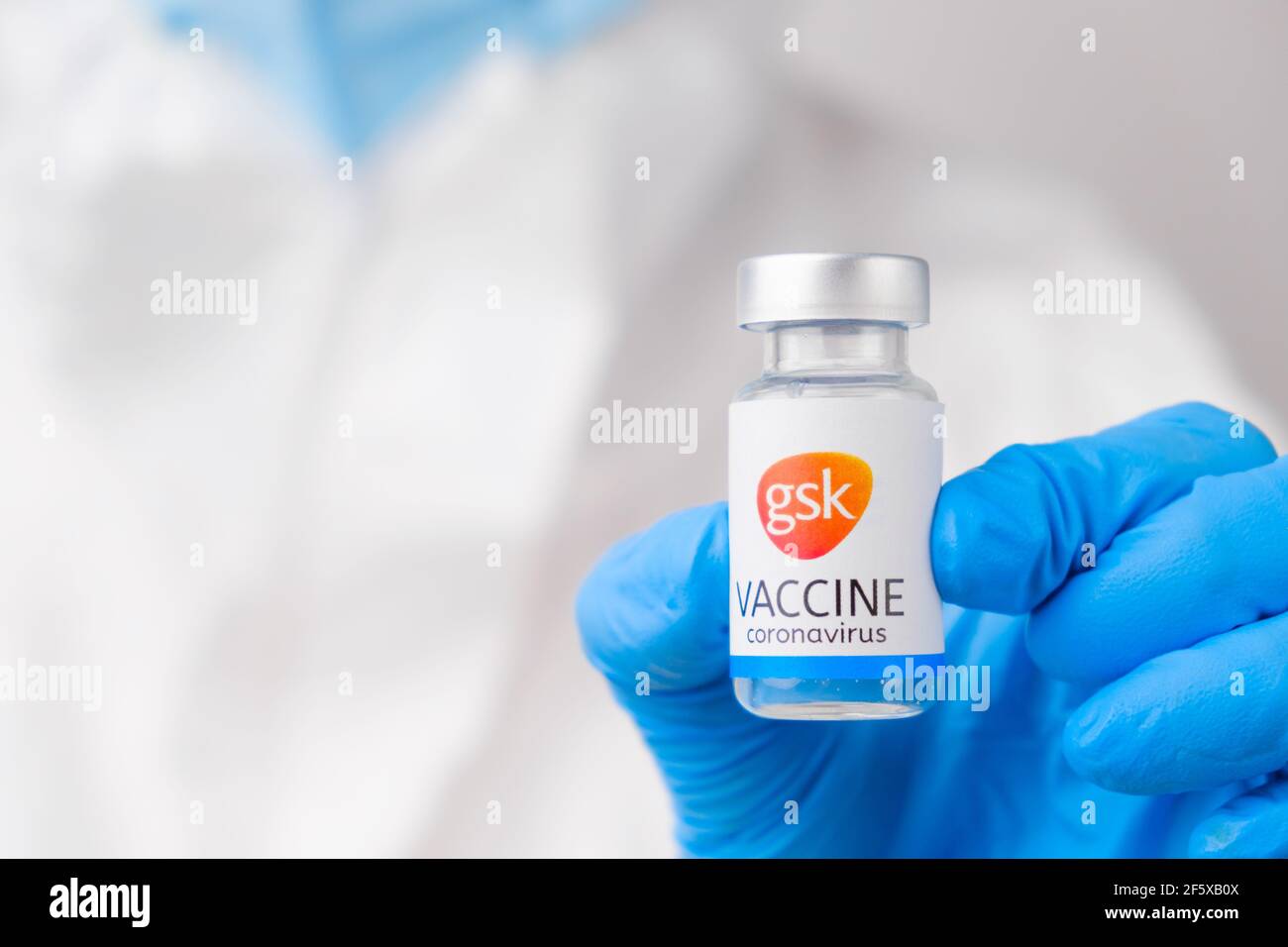 Vaccino GSK contro Covid-19, coronavirus o SARS-Cov-2 in mano medica in guanti di gomma. Foto Stock