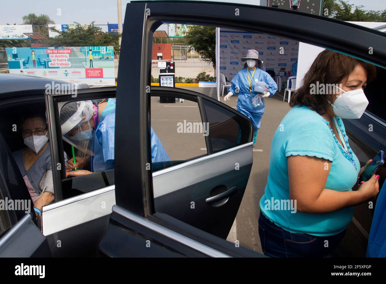 Un gruppo di operatori ospedalieri si occupa del processo di vaccinazione contro Covid-19 presso il Vaccine Car Centre Parque de las Leyendas. Il Vaccine Car è una procedura in cui le persone anziane vengono vaccinate contro Covid-19 all'interno delle proprie auto. È stato concepito per aiutare gli anziani che hanno difficoltà a camminare e a mobilitarsi. A partire da oggi 525,301 peruviani sono stati vaccinati contro Covid-19. Lima, Perú. Foto Stock