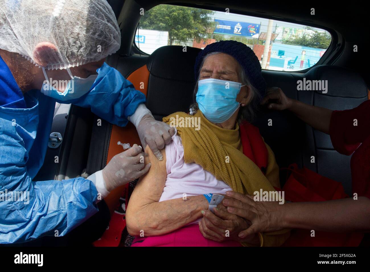 Una donna anziana riceve la prima dose del vaccino Pfizer contro Covid-19 al Vaccine Car Centre Parque de las Leyendas. Il Vaccine Car è una procedura in cui le persone sono vaccinate contro Covid-19 all'interno delle loro auto. È stato concepito per aiutare gli anziani, specialmente quelli che hanno difficoltà a camminare e a mobilitarsi. Il governo peruviano ha avviato il processo di vaccinazione a partire da persone di età superiore ai 85 anni. A partire da oggi 525,301 peruviani sono stati vaccinati contro Covid-19. Lima, Perú. Foto Stock
