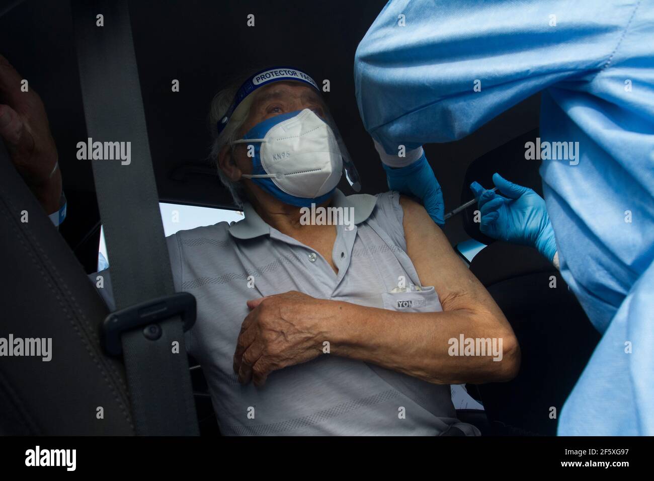 Un uomo anziano riceve la prima dose del vaccino Pfizer contro Covid-19 al Vaccine Car Centre Parque de las Leyendas. Il Vaccine Car è una procedura in cui le persone sono vaccinate contro Covid-19 all'interno delle loro auto. È stato concepito per aiutare gli anziani, specialmente quelli che hanno difficoltà a camminare e a mobilitarsi. Il governo peruviano ha avviato il processo di vaccinazione a partire da persone di età superiore ai 85 anni. A partire da oggi 525,301 peruviani sono stati vaccinati contro Covid-19. Lima, Perú. Foto Stock