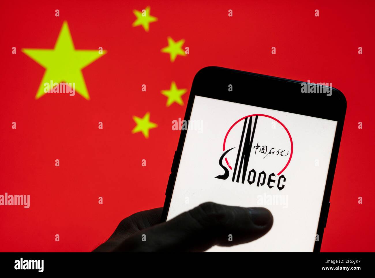 Cina. 27 Marzo 2021. In questa foto è illustrato il più grande conglomerato petrolchimico, gas e petrolio del mondo China Petrolchimica Corporation o il logo del Gruppo Sinopec visto su un dispositivo mobile Android con bandiera della Repubblica popolare Cinese sullo sfondo. Credit: Budrul Chukrut/SOPA Images/ZUMA Wire/Alamy Live News Foto Stock