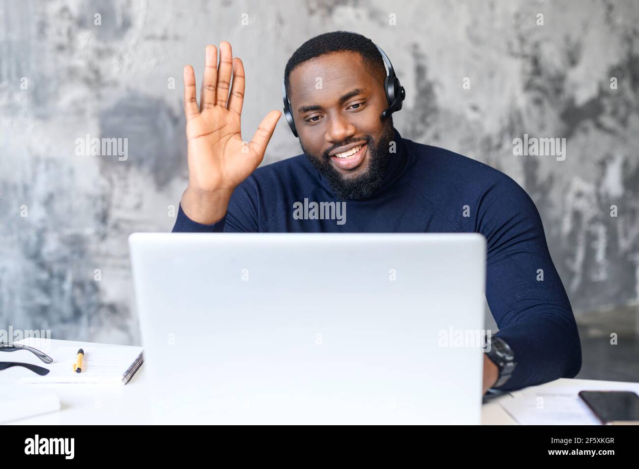Uomo d'affari nero che effettua videochiamata, guarda lo schermo del laptop, discute di strategia con i partner online, webinar di registrazione del mentore del tutor aziendale millenario, responsabile delle ore che tiene un colloquio di lavoro a distanza Foto Stock