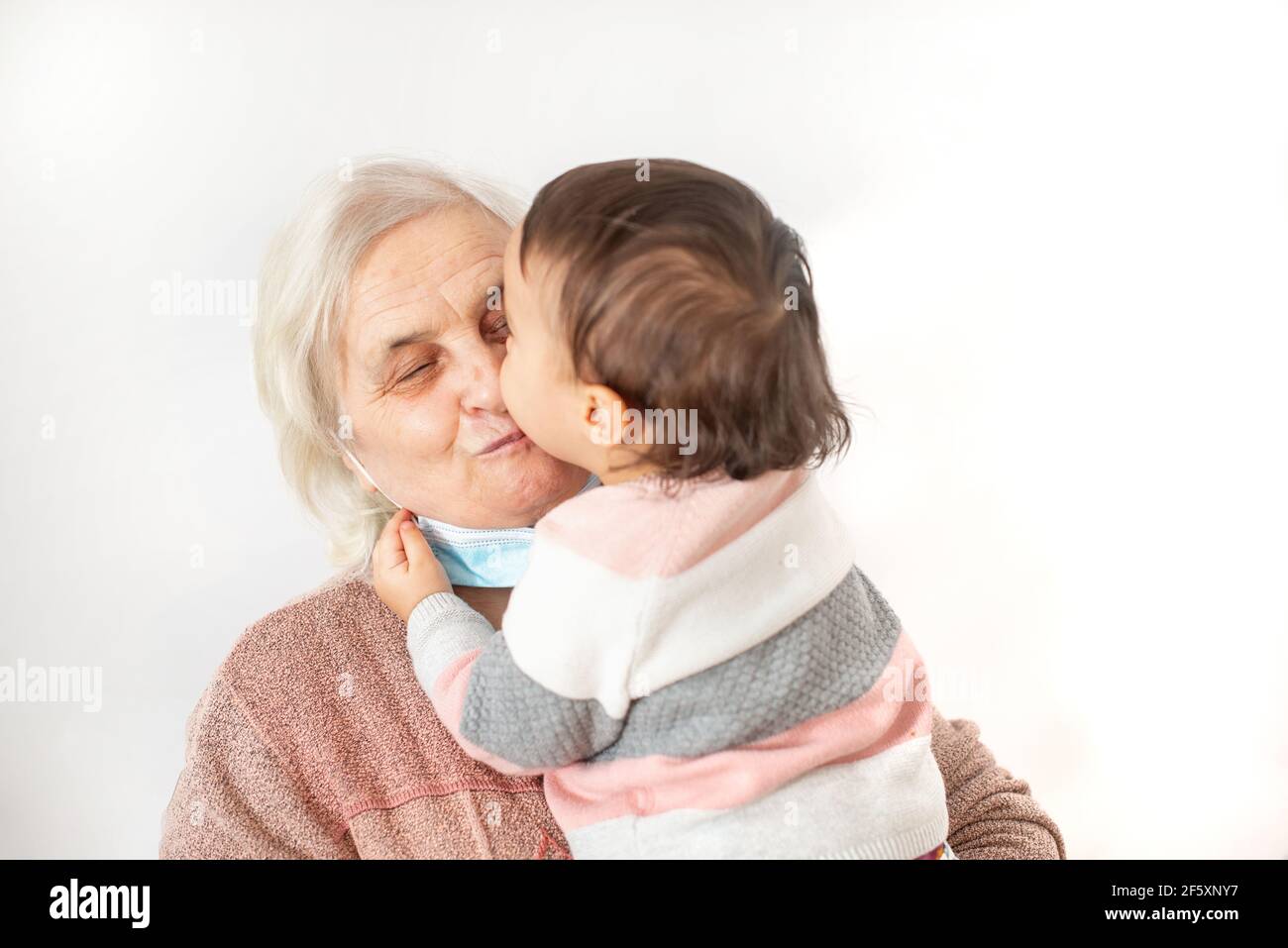 Nipote baciare la nonna dopo essere uscito dalla quarantena Foto Stock