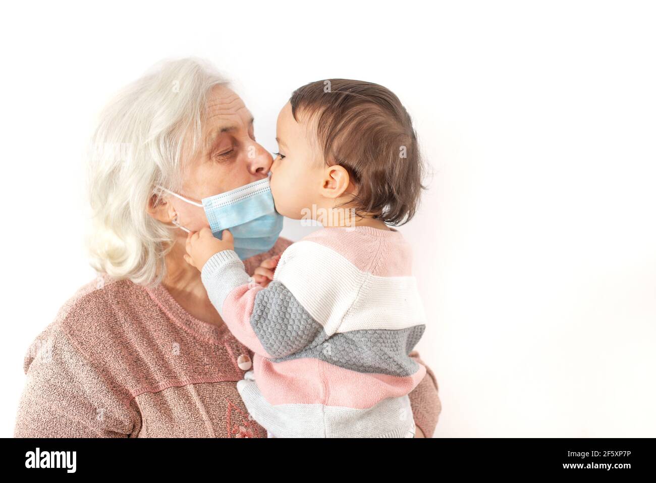 Nipote baciare la nonna dopo essere uscito dalla quarantena Foto Stock