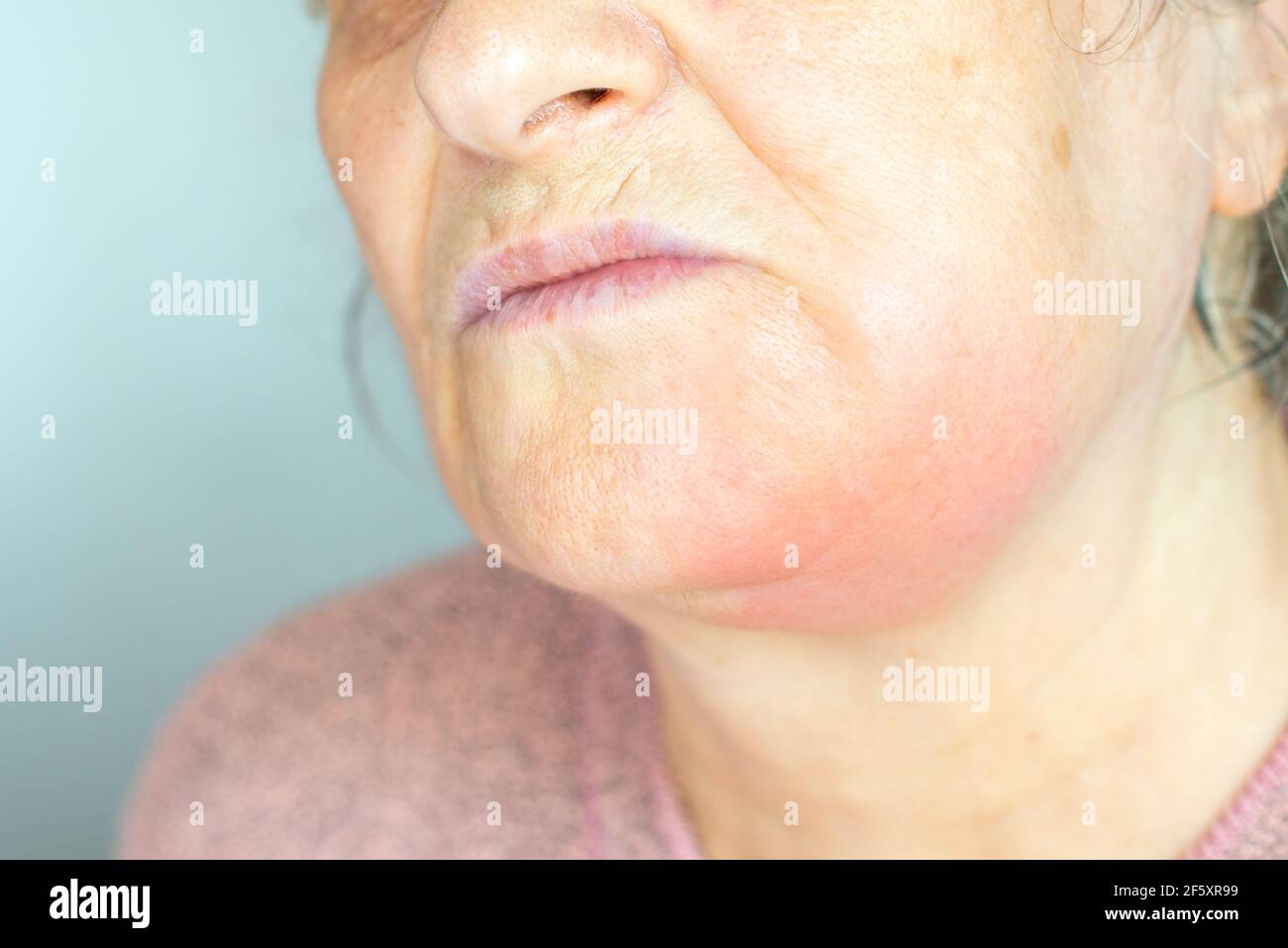 Donna matura depressa isolata su sfondo grigio studio guancia tocco sofferente di dolore dentale Foto Stock