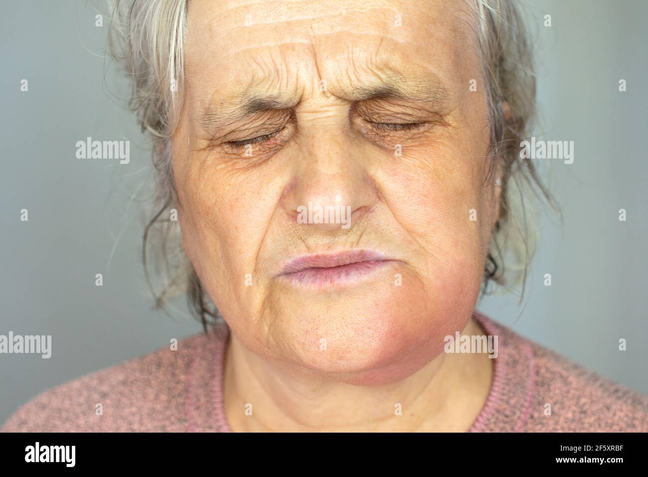 Donna matura depressa isolata su sfondo grigio studio guancia tocco sofferente di dolore dentale Foto Stock