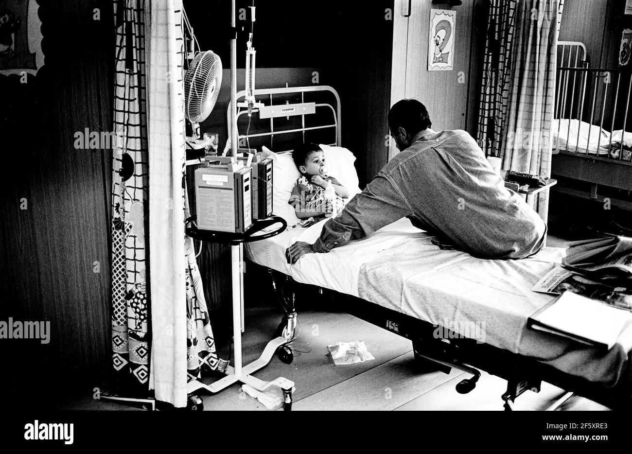 Addenbrookes Hospital Cambridge infantile reparto 1998 dove il padre del giovane paziente protegge suo figlio dal timore di essere in ospedale uno Di serie di fotografie che celebrano i 50 anni del NHS Foto Stock