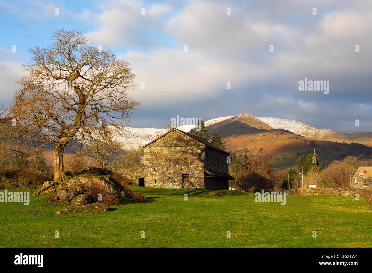 Granaio di pietra e montagne innevate, Ambleside, Lake District, Cumbria Foto Stock