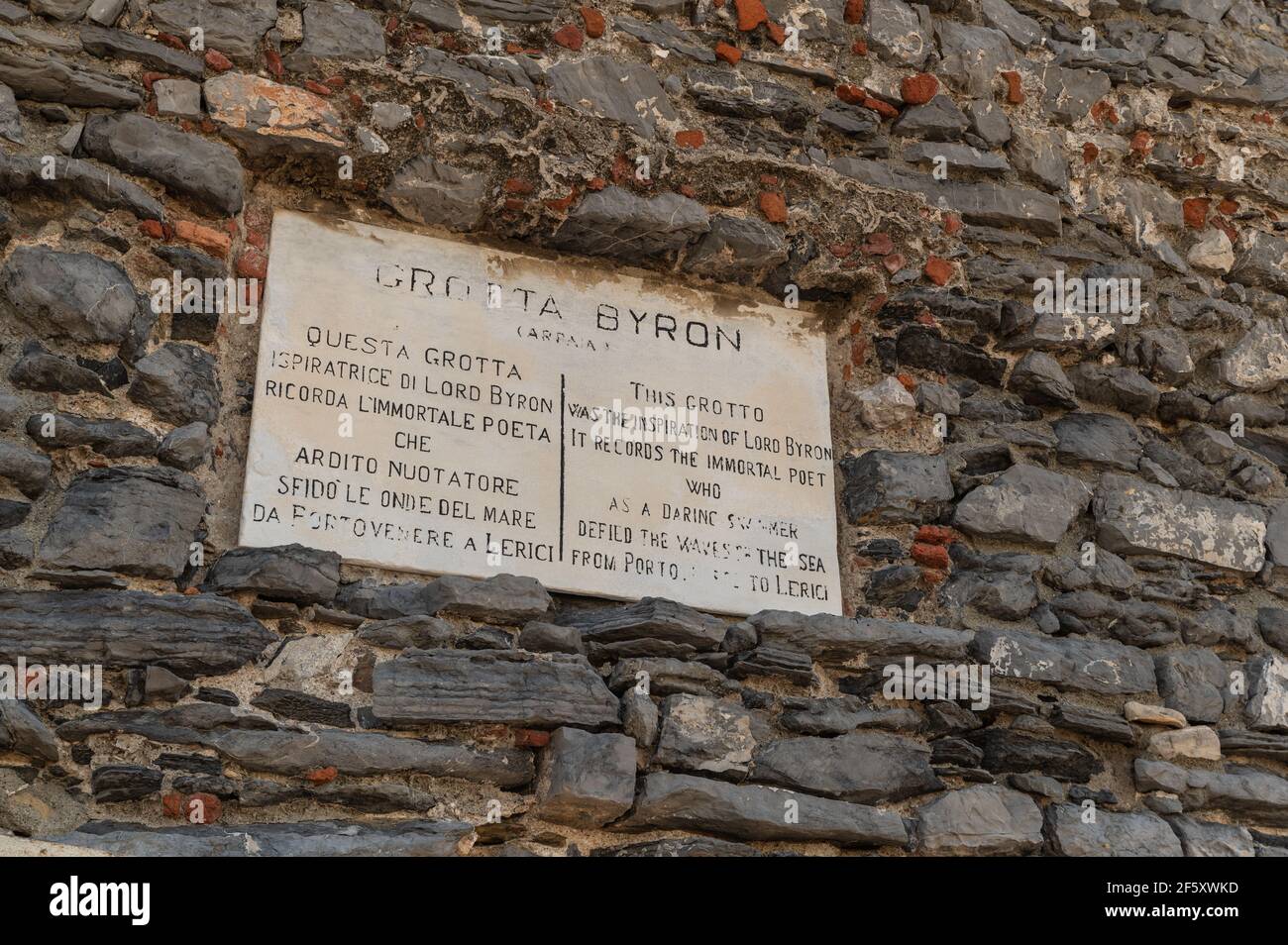 Portovenere, Liguria, Italia. Sopra l'ingresso della Grotta del Signore Byron una lapide commemorativa in marmo su un antico muro di pietra appartenente al D. Foto Stock