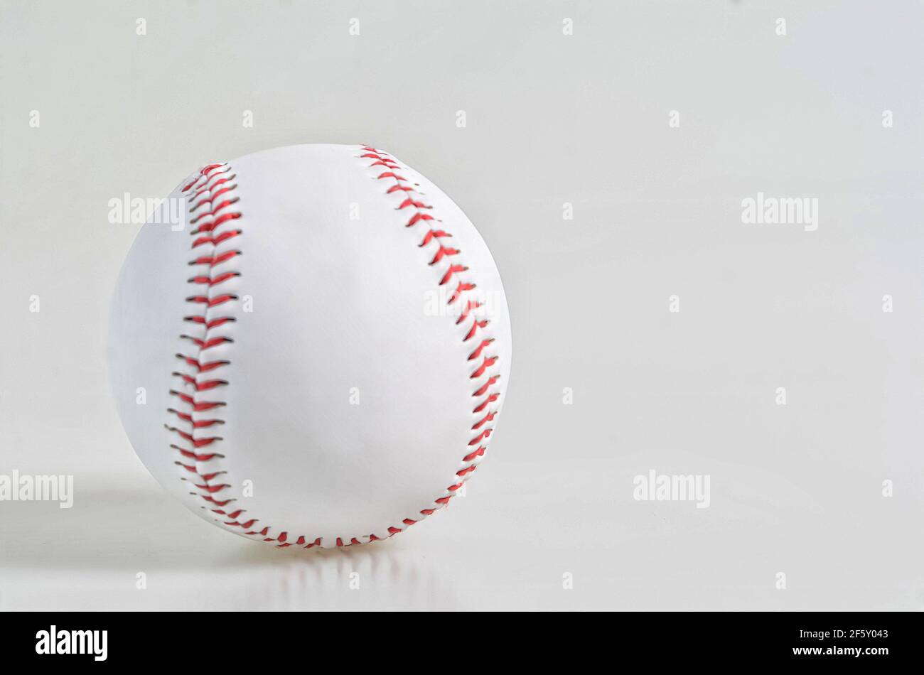 Un singolo baseball isolato su sfondo bianco. Punti di messa a fuoco selettivi. Sfondo sfocato Foto Stock