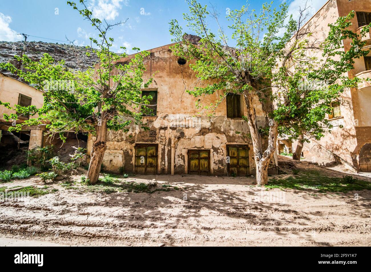 Aouli, Marocco - 10 aprile 2015. Porte verdi arrugginite di casa abbandonata, in parte sepolte dalla sabbia Foto Stock