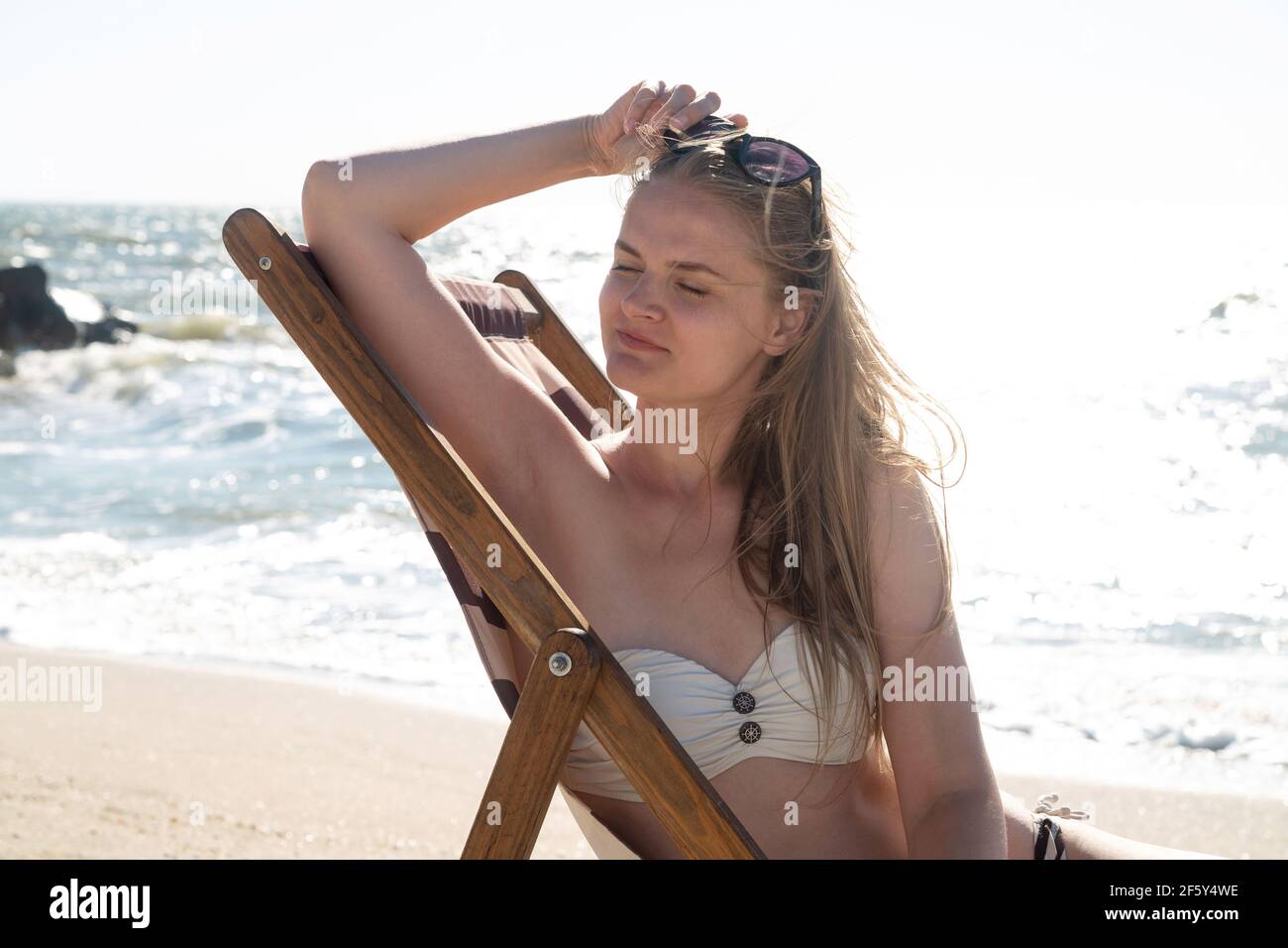 Felice bella donna alla luce del sole sulla spiaggia Foto Stock