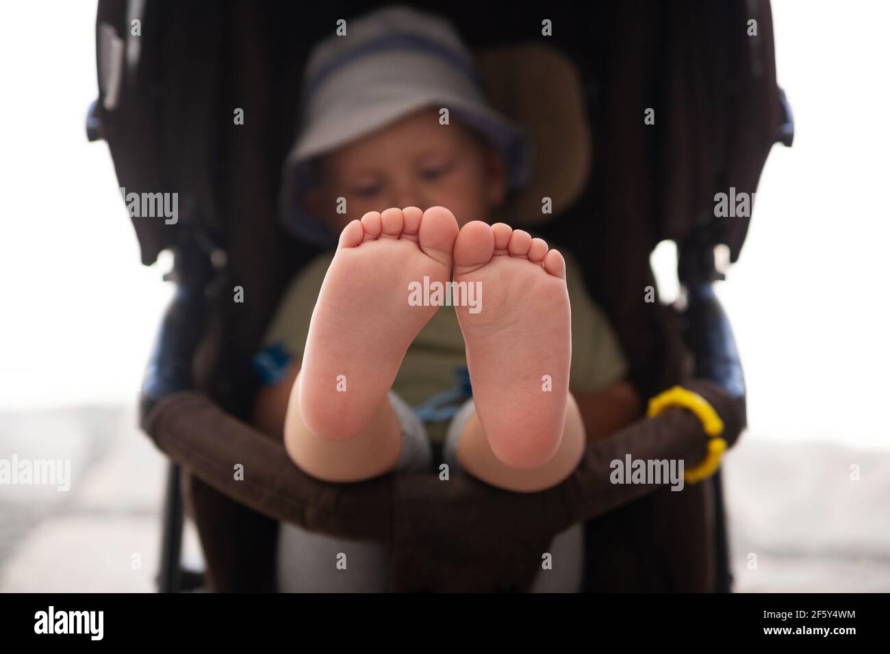 I piedi del bambino sono seduti in un guardaroba di passeggino Foto Stock