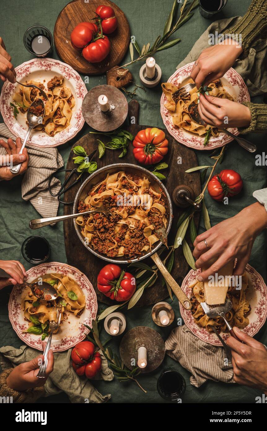 La famiglia mangia tagliatelle di pasta bolognese a cena in stile italiano Foto Stock