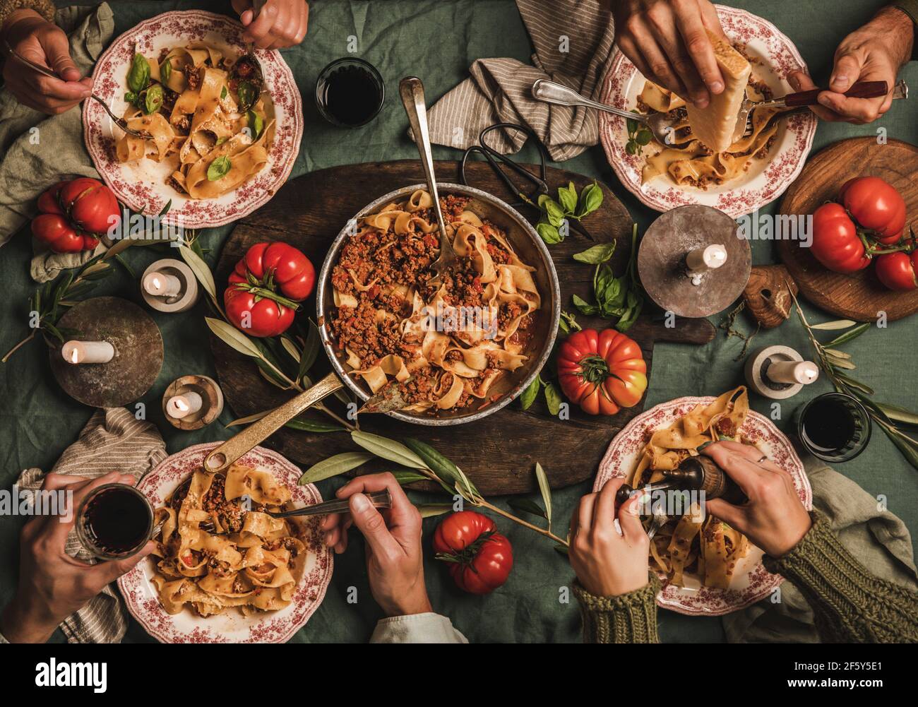 La gente mangia tagliatelle bolognese a cena di famiglia gathering Foto Stock