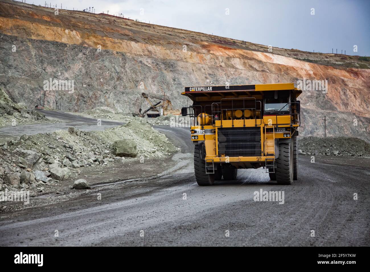 Rudny, Kazakhstan - Maggio 14 2012: Miniera a cielo aperto di minerale di ferro in cava. I dumper da cava Caterpillar trasportano il minerale all'impianto di concentrazione Foto Stock