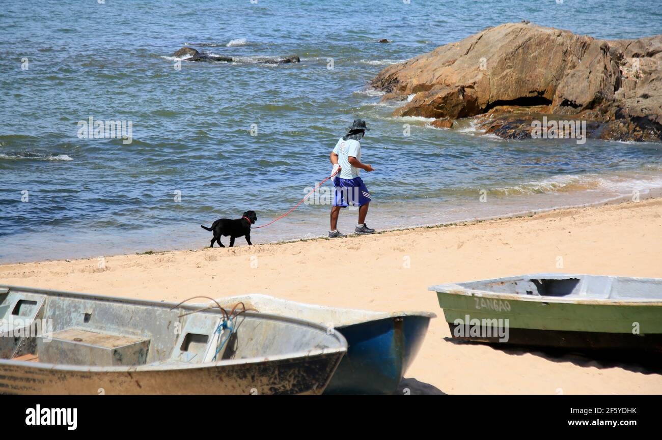 salvador, bahia, brasile - 21 gennaio 2021: La persona è vista con un cane sulla spiaggia di Itapua nella città di Salvador. *** Local Caption *** Foto Stock