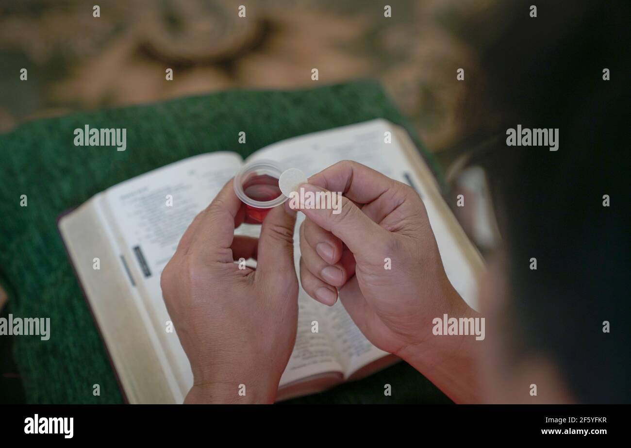 L'uomo che tiene pane e vino nella comunione o nell'Eucaristia, commemorando l'ultima cena. Foto Stock