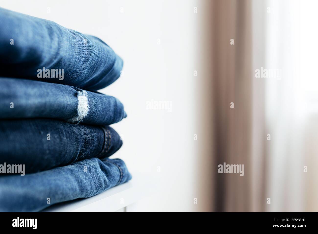 Una pila di jeans o pantaloni in denim blu. Concetto di industria tessile. Concetto di negozi di abbigliamento. Concetto di vendita. Foto di alta qualità Foto Stock