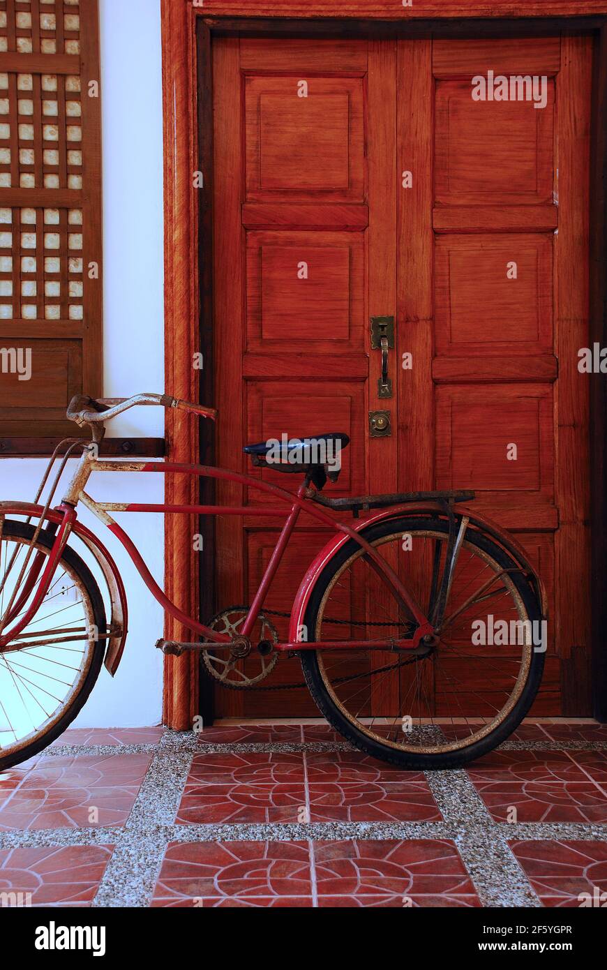 Usurata bici d'epoca appoggiata al muro di una casa ancestrale. Foto Stock