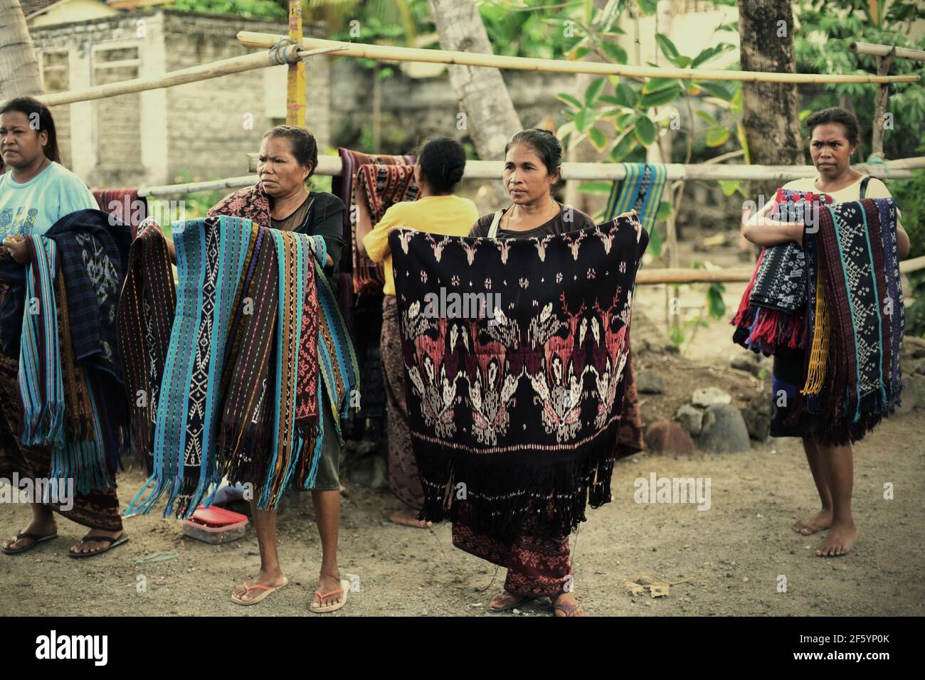 Donne che espongono tessuti tradizionali per catturare l'attenzione dei turisti a Sikka, sull'isola di Flores, a Nusa Tenggara, Indonesia. Foto Stock