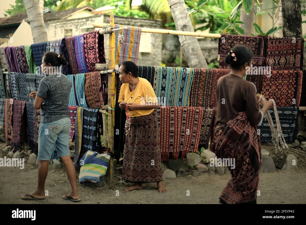 Donne che espongono tessuti tradizionali per catturare l'attenzione dei turisti a Sikka, sull'isola di Flores, a Nusa Tenggara, Indonesia. Foto Stock