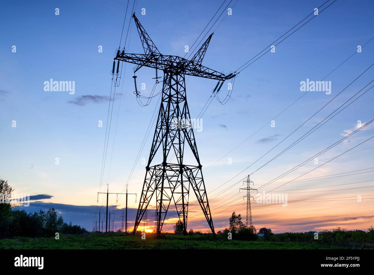 Tramonto con linee elettriche, paesaggio industriale Foto Stock