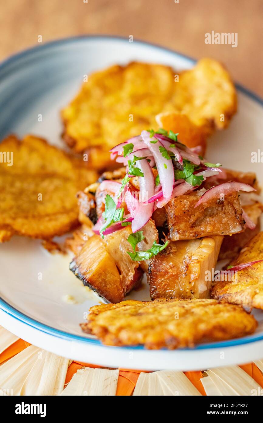 un piatto di piantana fritta servito con manzo grattugiato a gocce con ravvivatura di cipolla e lime Foto Stock
