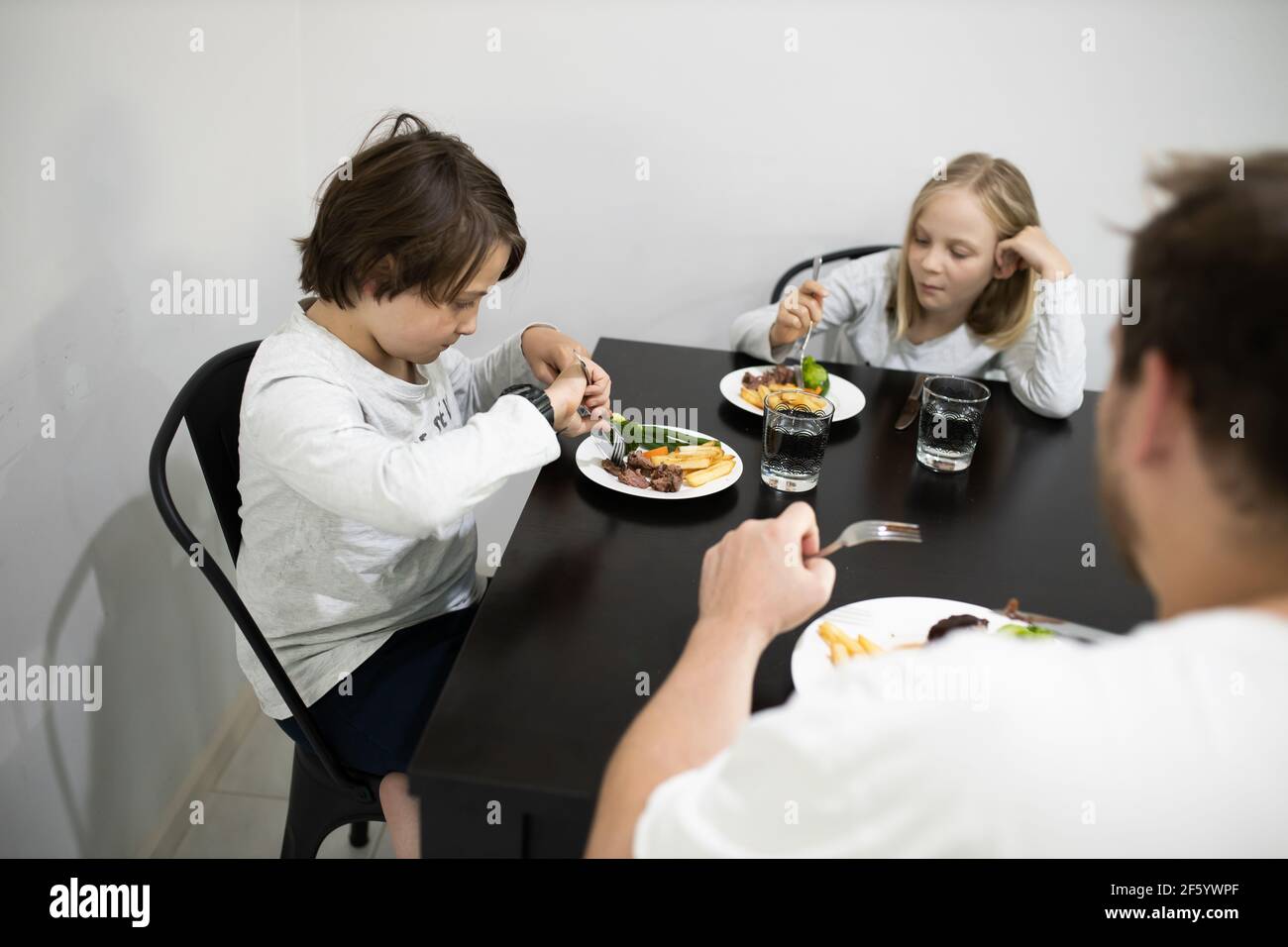 Famiglia che mangia una sana cena a un tavolo Foto Stock