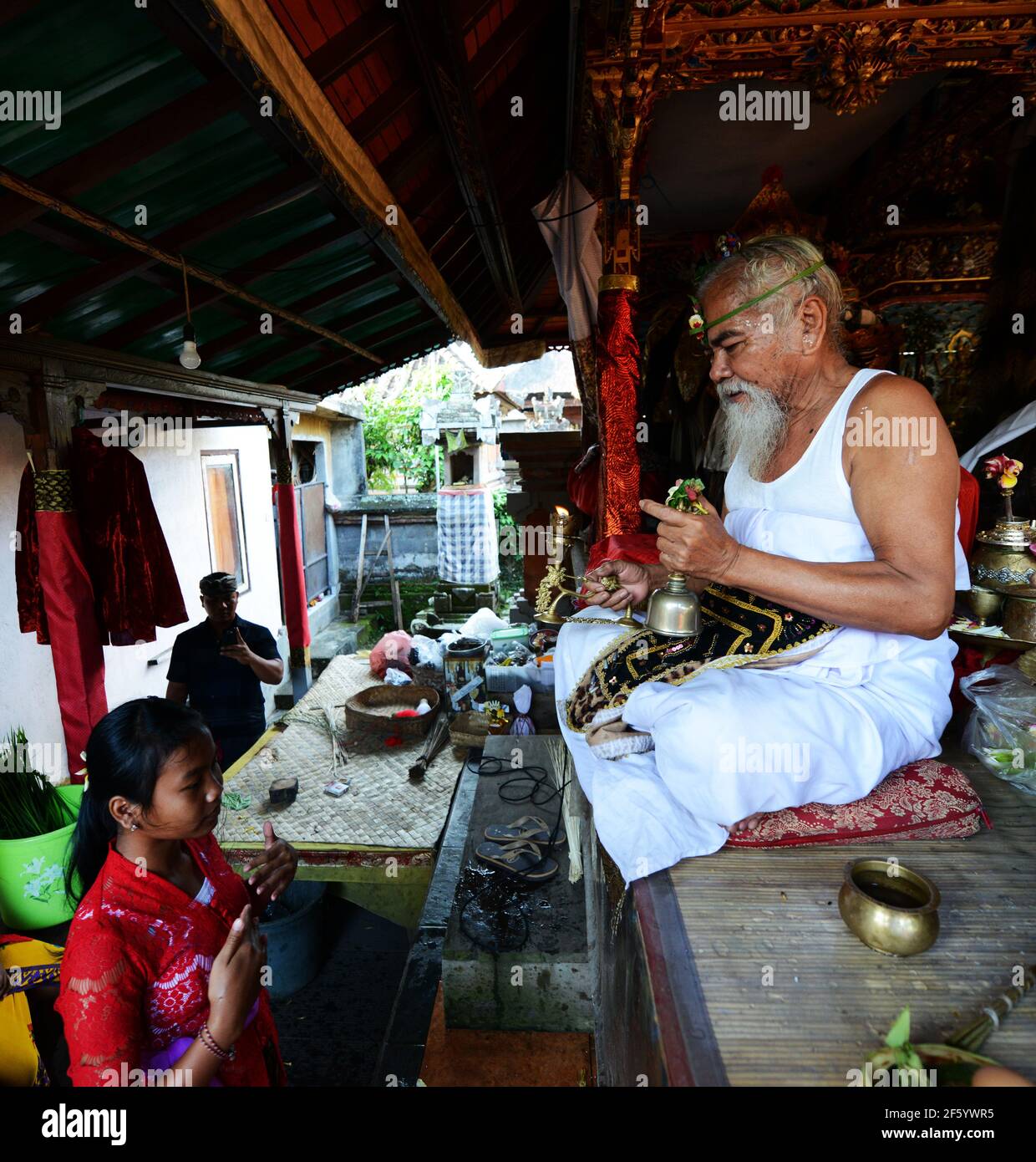 Un prete indù balinese benedice uno sposo in una cerimonia pre-matrimonio in un piccolo tempio a Ubud, Bali, Indonesia. Foto Stock