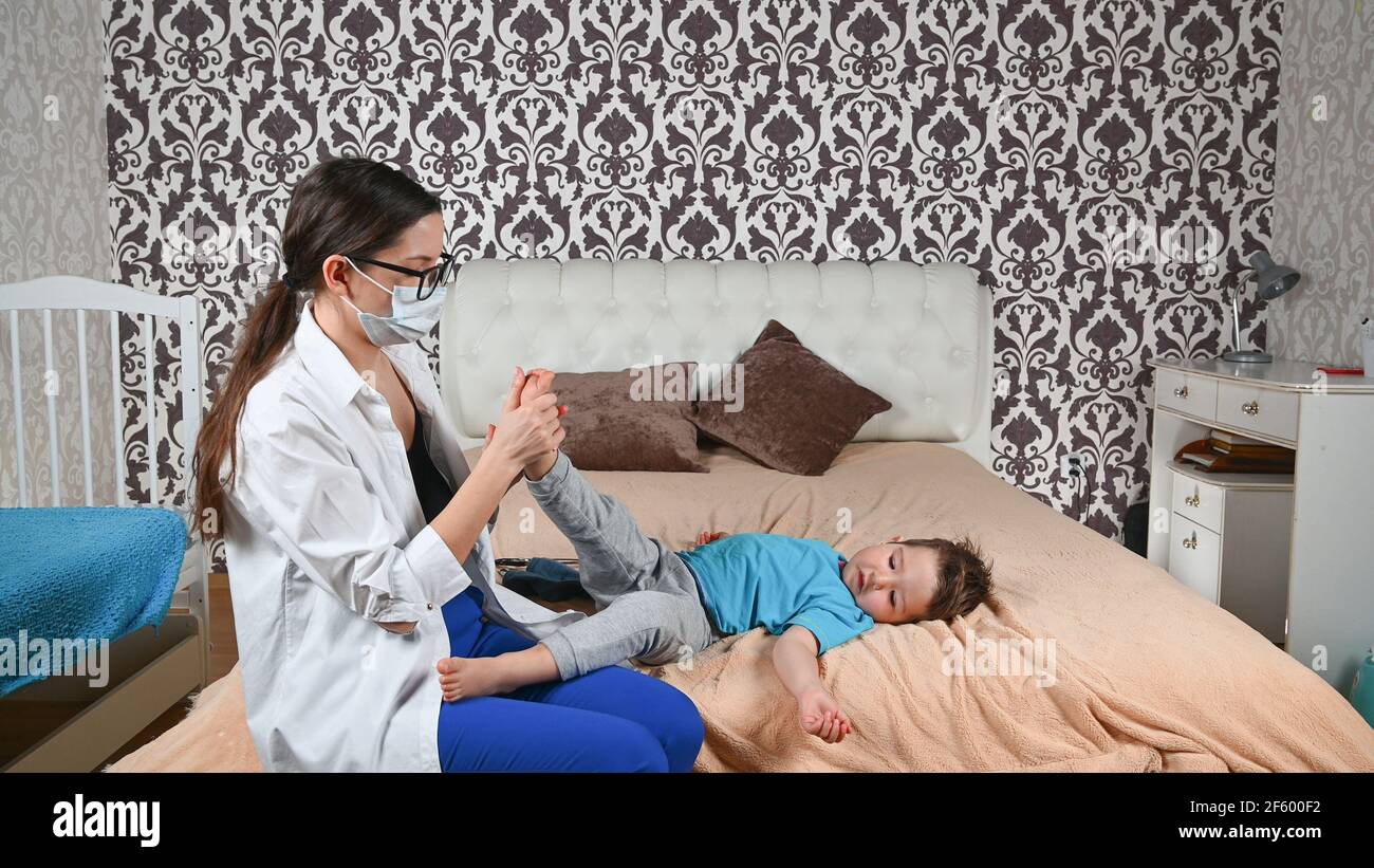 Il medico controlla le gambe del bambino. Foto Stock