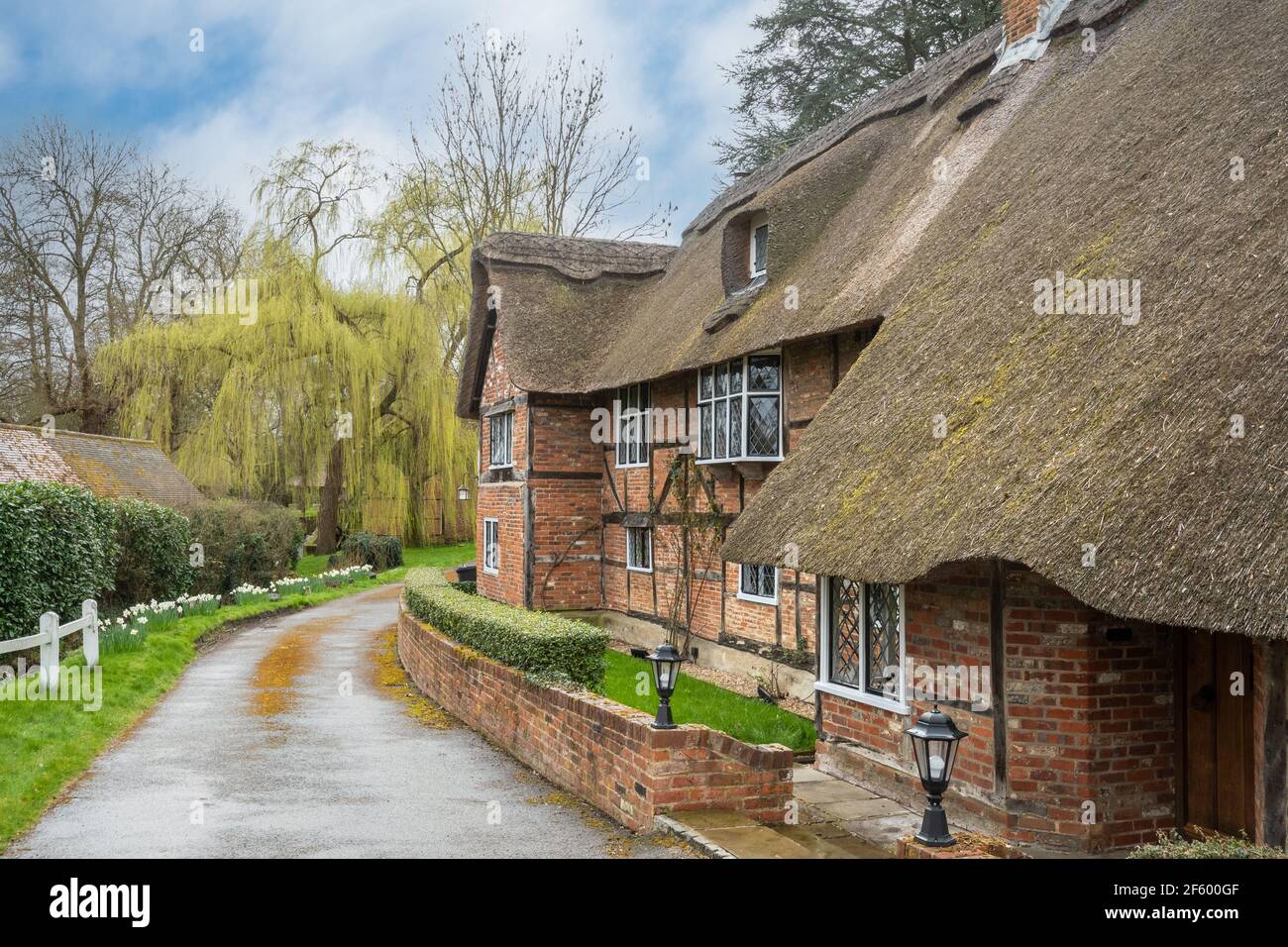 Storico 17 ° secolo di grado II elencati cottage con tetto di paglia chiamato le caserme nel villaggio di Dogmersfield, Hampshire, Inghilterra, Regno Unito Foto Stock