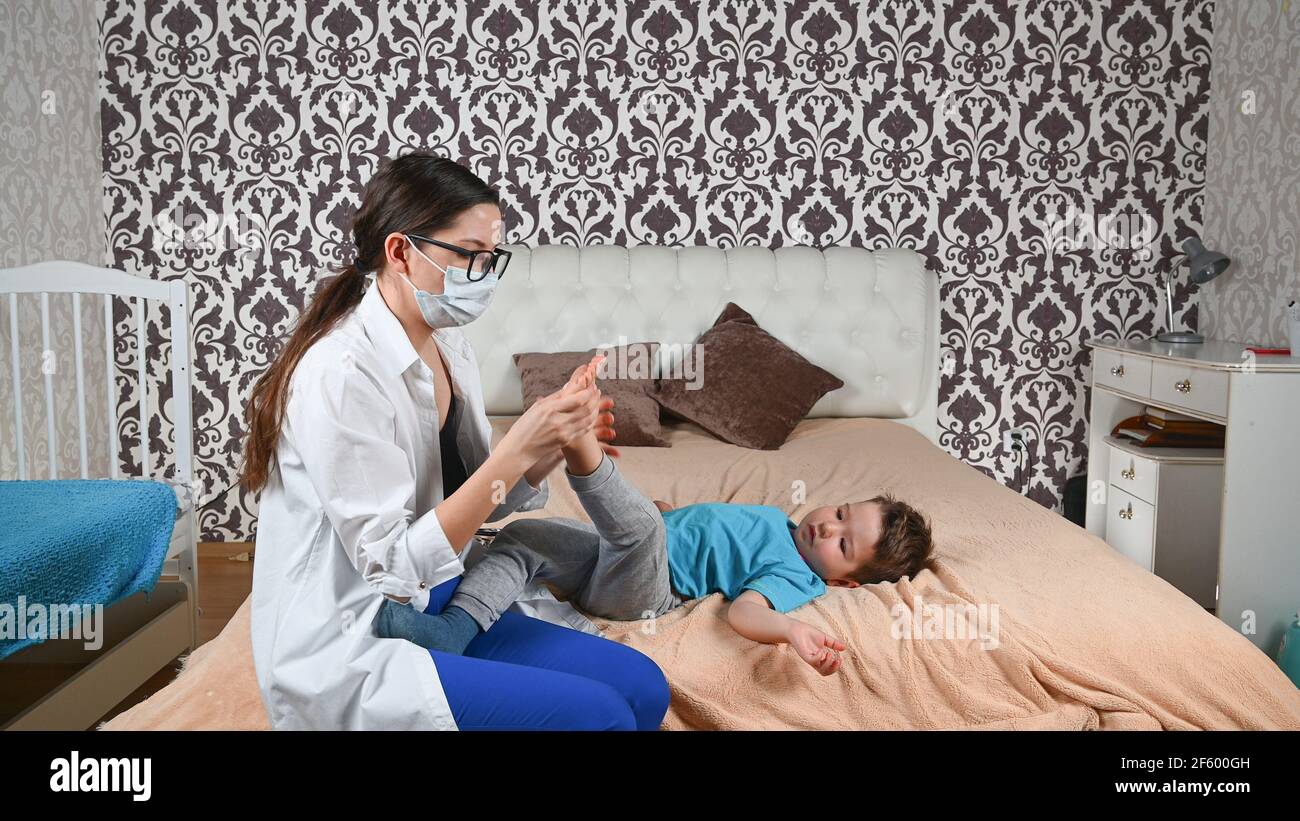 Il medico controlla le gambe del bambino. Foto Stock