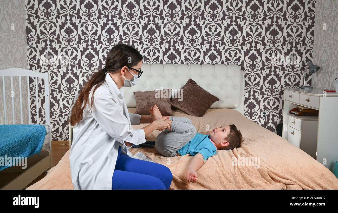 Il medico controlla le gambe del bambino. Foto Stock