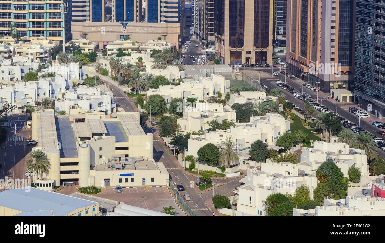 Una lussuosa area residenziale di Abu Dhabi con ville accanto alla Corniche, con moderni blocchi a torre sullo sfondo. Foto Stock