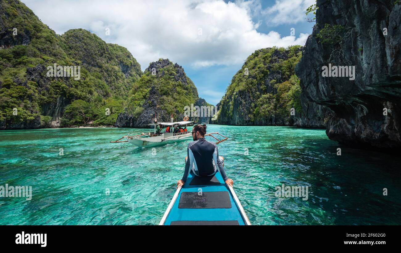 El Nido, Palawan, Filippine, viaggiatore seduto sul ponte della barca per esplorare le attrazioni naturali intorno a El Nido in una giornata di sole. Foto Stock