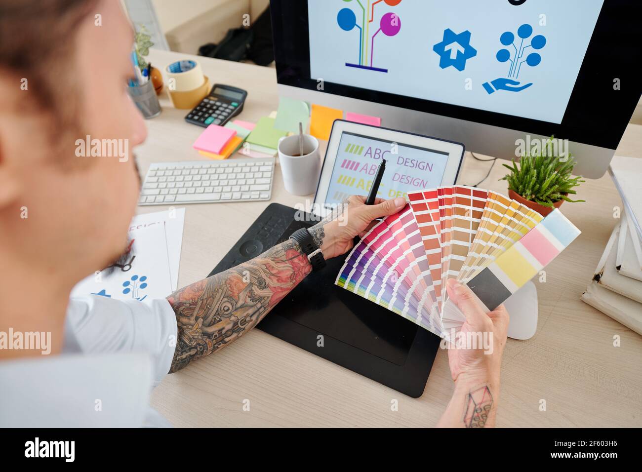 Mani di graphic designer che guardano la tavolozza e scelgono il colore per registro aziendale Foto Stock