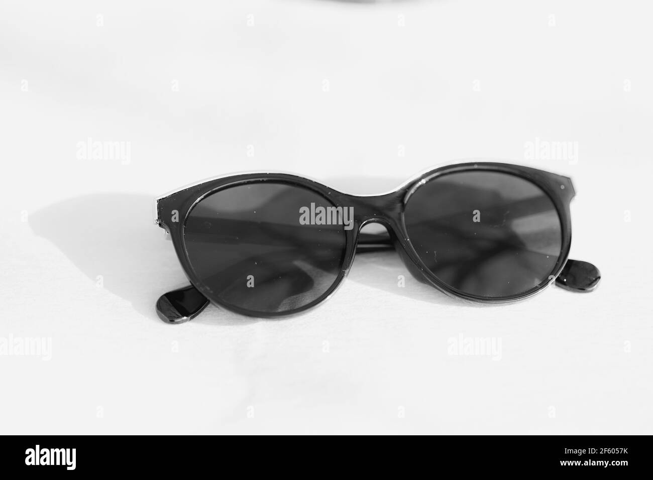 Modello di occhiali da sole di moda Cat eye per Signore con grandi lenti rotonde nere e nero telaio sparare all'esterno in un closeup di giorno soleggiato. Messa a fuoco selettiva Foto Stock