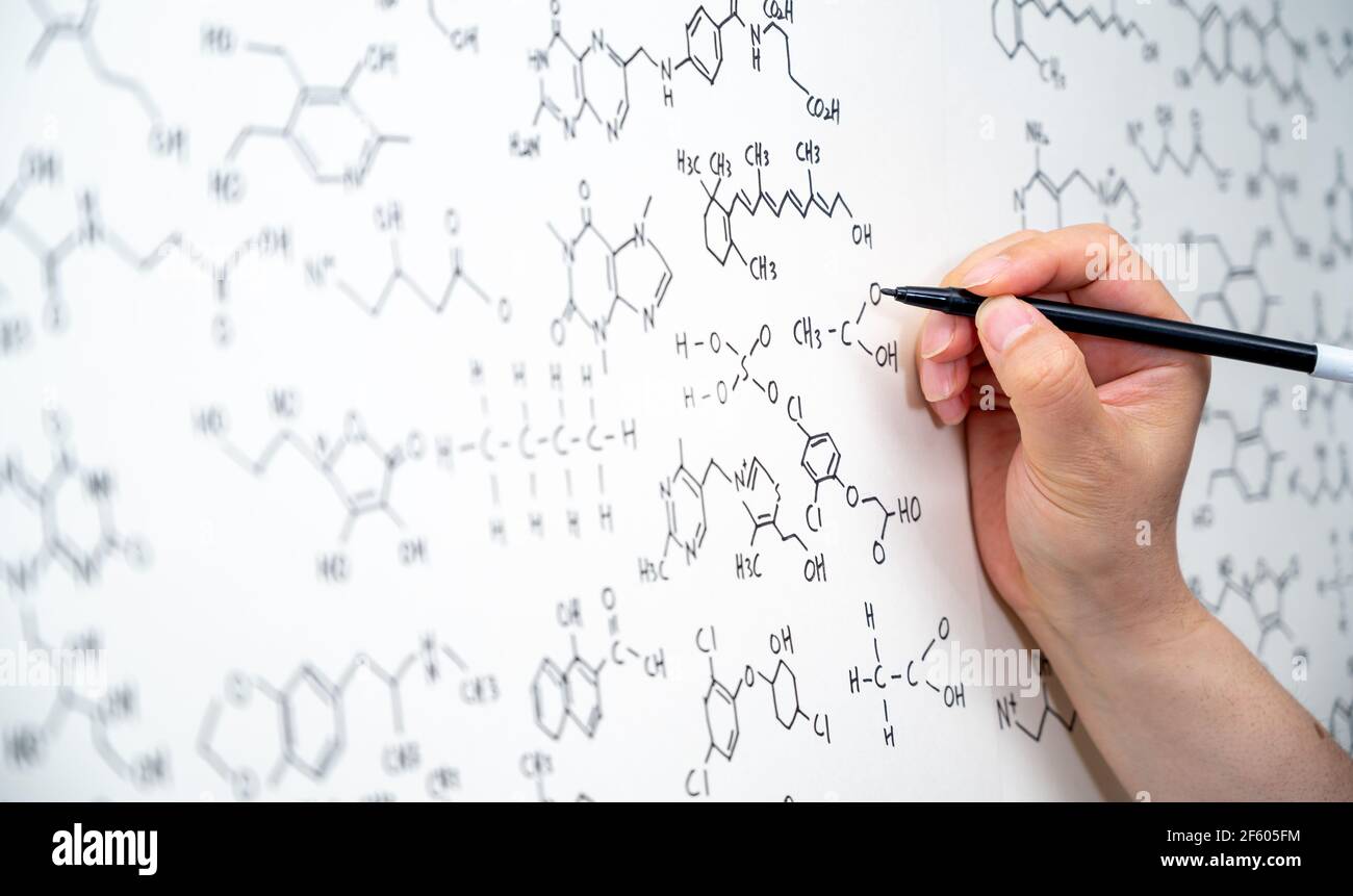 Varie formule chimiche sono scritte sulla lavagna. Contesto scientifico del concetto. Foto Stock