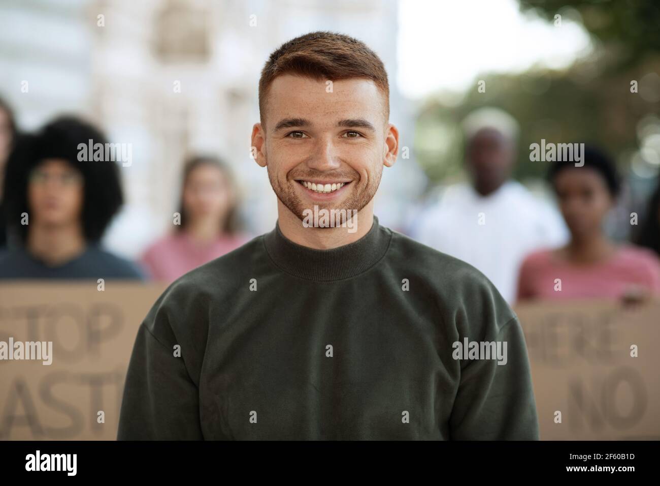 Un ragazzo allegro su un gruppo internazionale di manifestanti Foto Stock