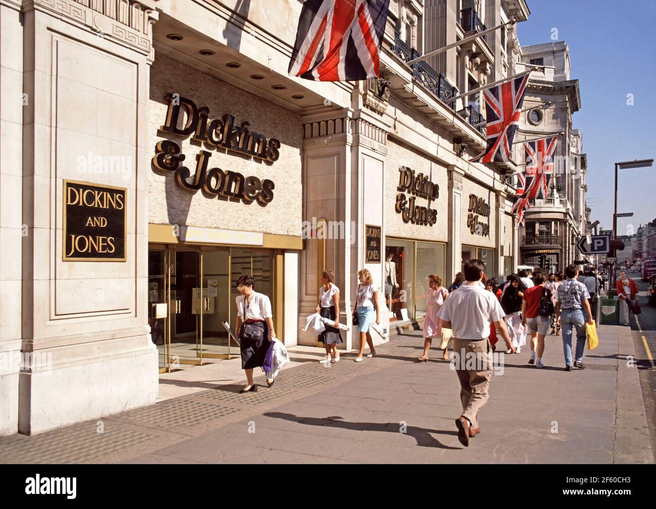 Archivio storico 1988 vista di una soleggiata scena di strada estiva Paesaggio urbano nella famosa Regent Street shopping e turistico destinazione con gli uomini e le donne che fanno shopping a piedi lungo il marciapiede fuori Anni '80 Dickens & Jones, grandi magazzini di alta classe, negozi al dettaglio façade e ingresso anteriore con union jack bandiere in alto in un archivistica in cui eravamo l'immagine della moda degli anni '80 West End di Londra Inghilterra Regno Unito Foto Stock