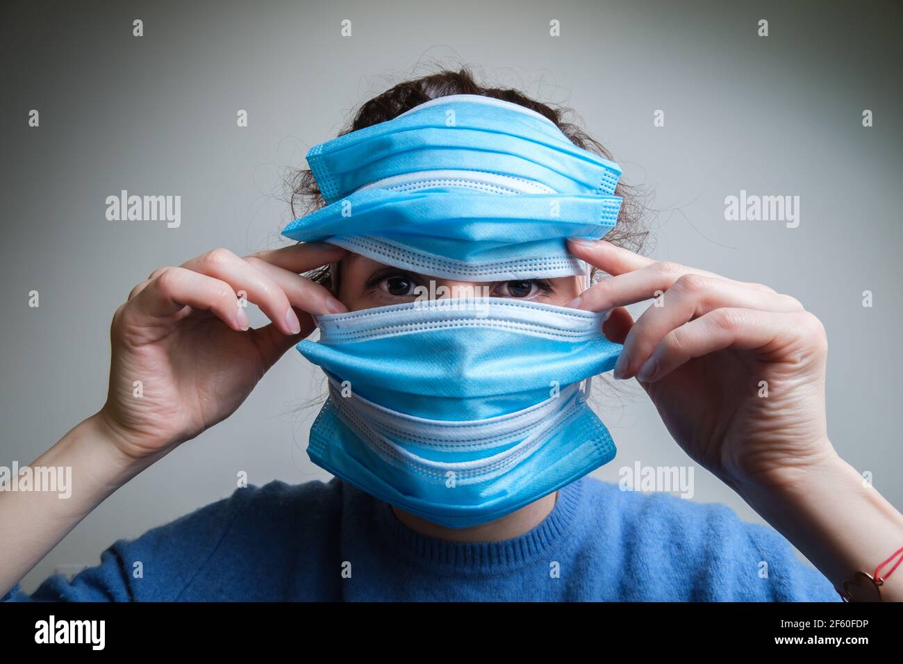 Ragazza con molte maschere sul viso Foto Stock