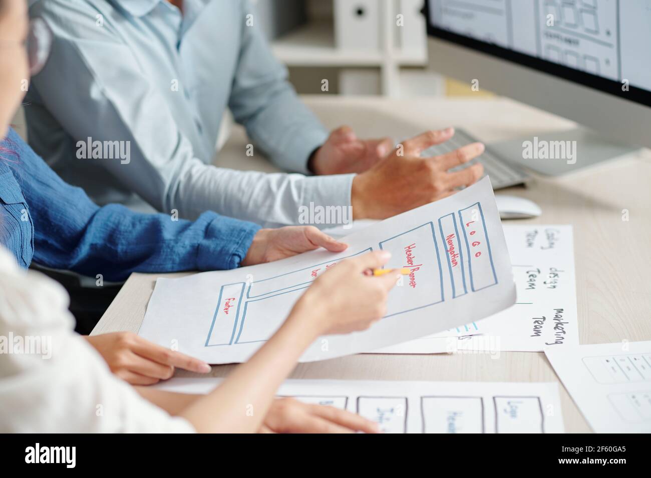 Le mani dei progettisti di UI e UX che discutono cosa cambiare nella progettazione del layout delle applicazioni mobili Foto Stock