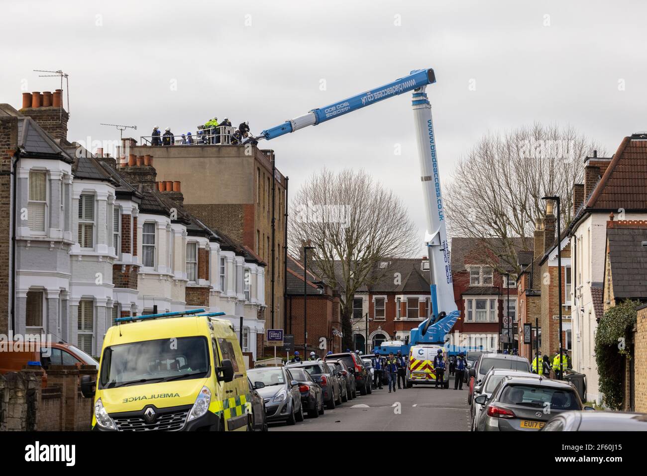 Londra, Regno Unito. 29 marzo 2021. Una gru viene utilizzata per accedere ai dimostranti sul tetto. La stazione di polizia è stata occupata da squadranti e attivisti autonomi sotto il nome di ‘Not A Cop Shop’ per oltre una settimana, in opposizione alla nuova ‘polizia, crimine, condanna e tribunali Bill’ e femminicidio. Cavendish Road Police Station, Clapham, Londra, Regno Unito. Credit: Joshua Windsor/Alamy Live News. Foto Stock