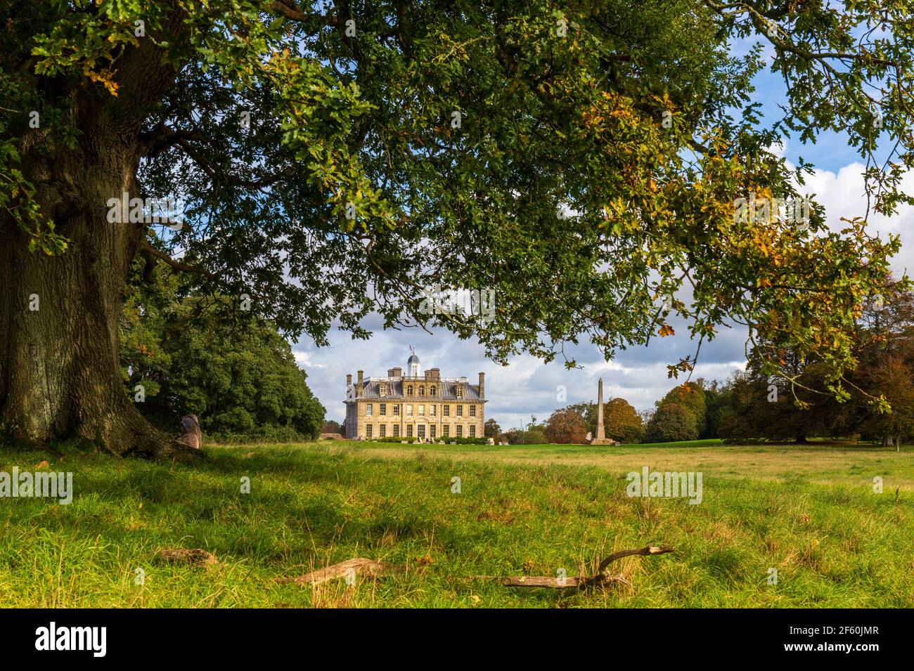 Una vista sud della casa di Kingston Lacy e Obelisco Egiziano attraverso rami di quercia, Dorset, Inghilterra Foto Stock