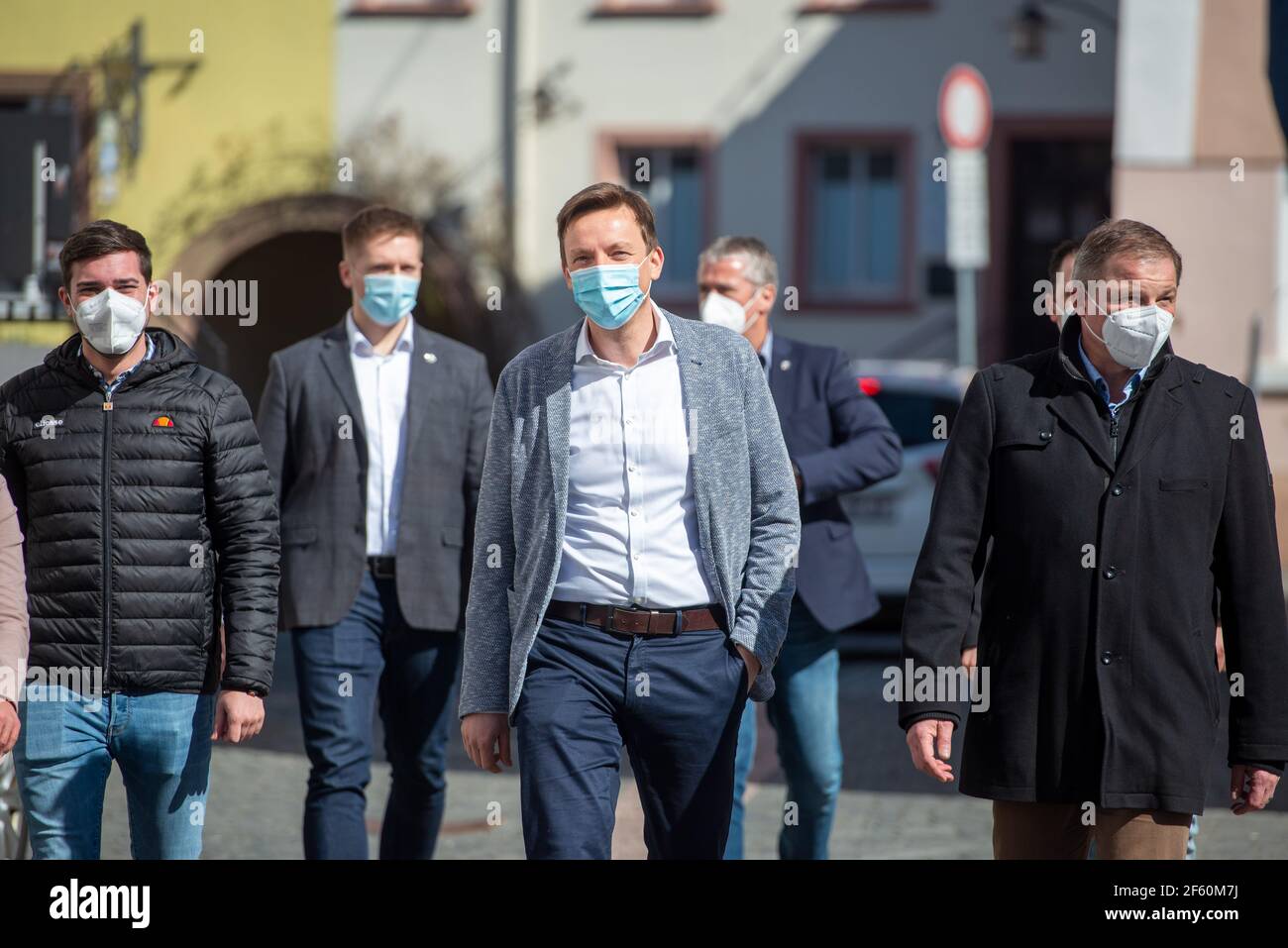 Ottweiler, Germania. 29 marzo 2021. Il presidente del ministro Saarland Tobias Hans (M, CDU) cammina con la sua squadra verso una stazione mobile di test Covid-19 di fronte a una farmacia. Nonostante le critiche, la Saarland si sta attenendo al suo progetto modello pianificato per il rilassamento attraverso test di massa. Credit: Harald Tittel/dpa/Alamy Live News Foto Stock