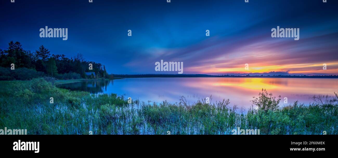 Un suggestivo tramonto primaverile sulla Mud Bay a Tofts Point vicino a Baileys Harbour nella Door County Wisconsin. Il Tofts Point è una riserva nazionale di zone umide. Foto Stock