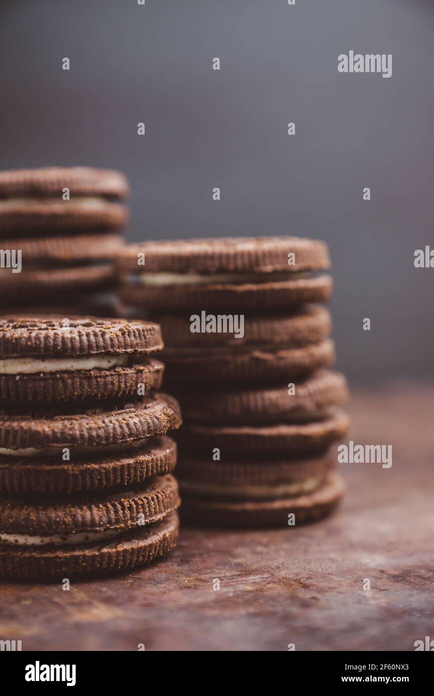 Pila di biscotti sandwich al cioccolato su rustico sfondo di legno. Messa a fuoco selettiva. Profondità di campo poco profonda. Foto Stock